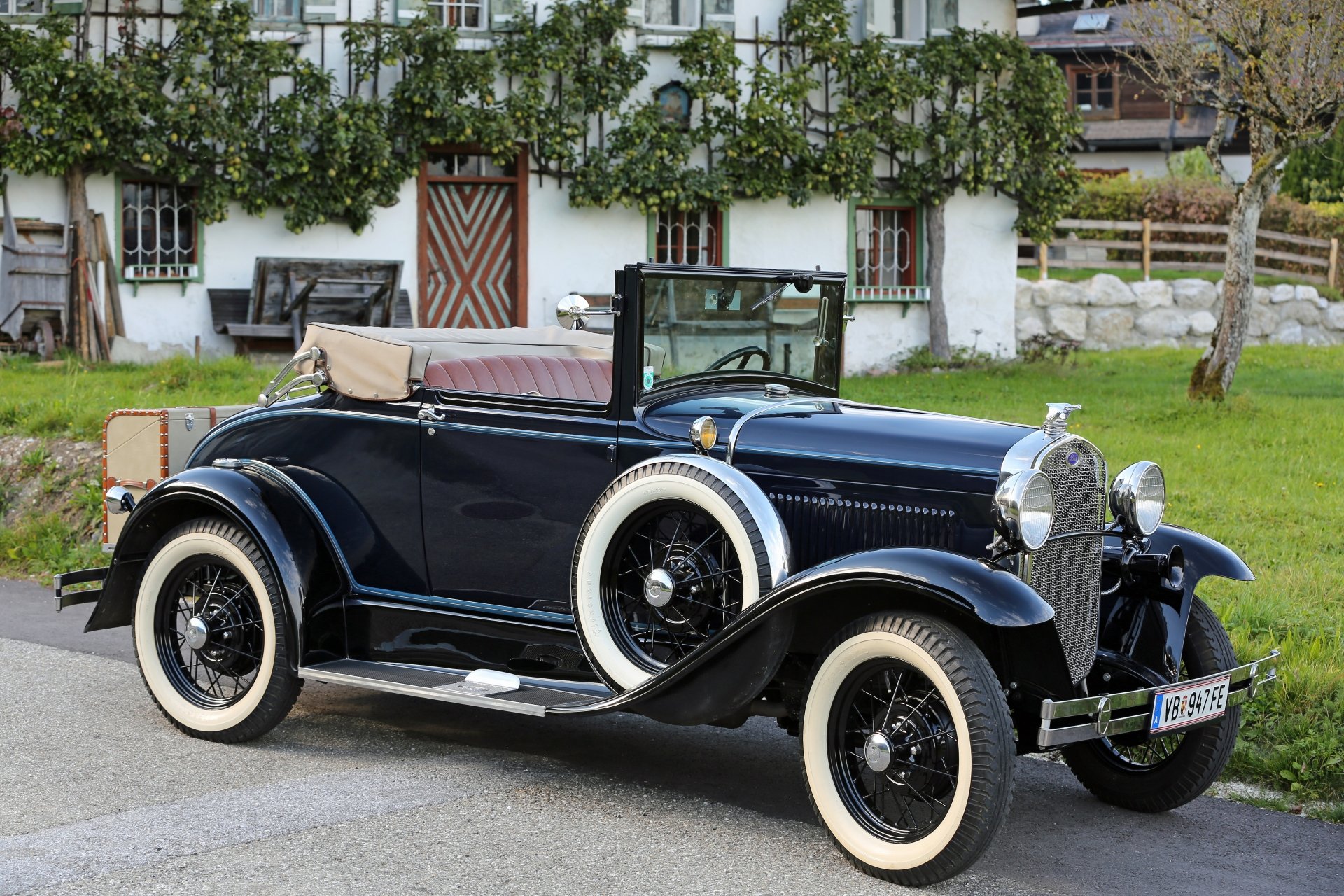 Vintage black Ford Model A convertible parked in front of a rustic house, captured in 4K Ultra HD as a classic car desktop wallpaper background.