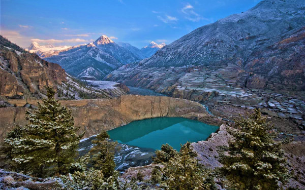 A stunning HD desktop wallpaper of Banff National Park in Canada, showcasing a serene lake surrounded by rugged mountains and a canyon, highlighting the breathtaking beauty of nature.