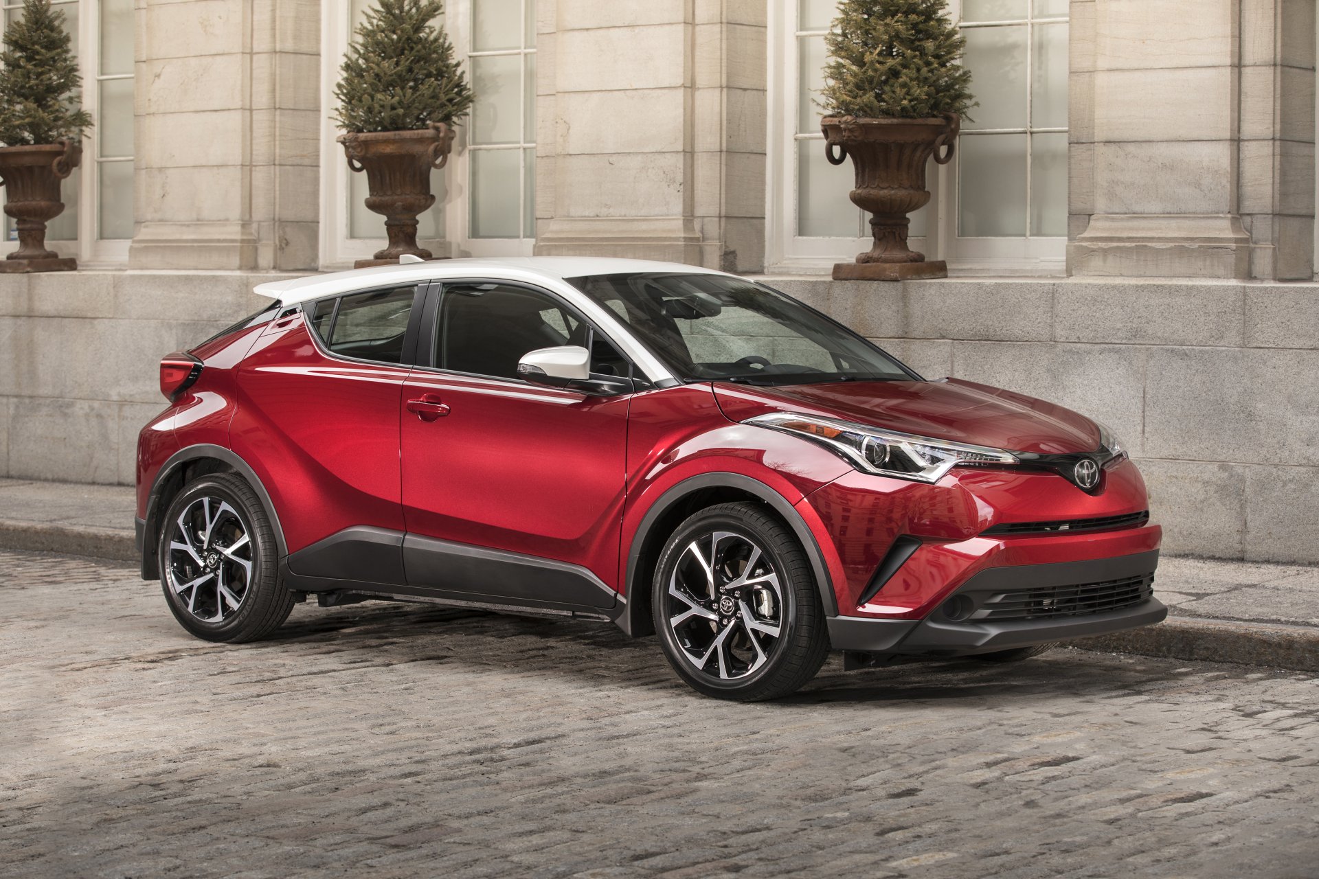 Red Toyota C-HR compact SUV car on a cobblestone street, 4K Ultra HD PC desktop wallpaper and background showcasing the vehicle's bold angular crossover design.