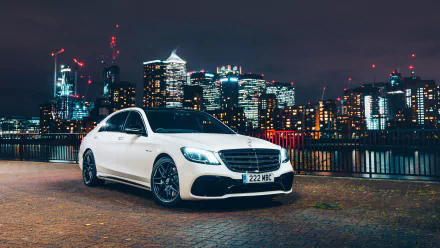 4K Ultra HD PC desktop wallpaper of a white Mercedes-AMG S63 Mercedes-Benz parked on a riverfront promenade with a glowing city skyline at night.