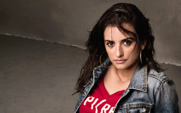 Brunette Spanish actress gazes at the camera wearing a denim jacket over a red top — 4K Ultra HD PC desktop wallpaper.
