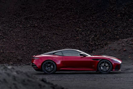 Aston Martin DBS Superleggera supercar in deep red, showcased against a dark, rugged background as an HD PC desktop wallpaper.