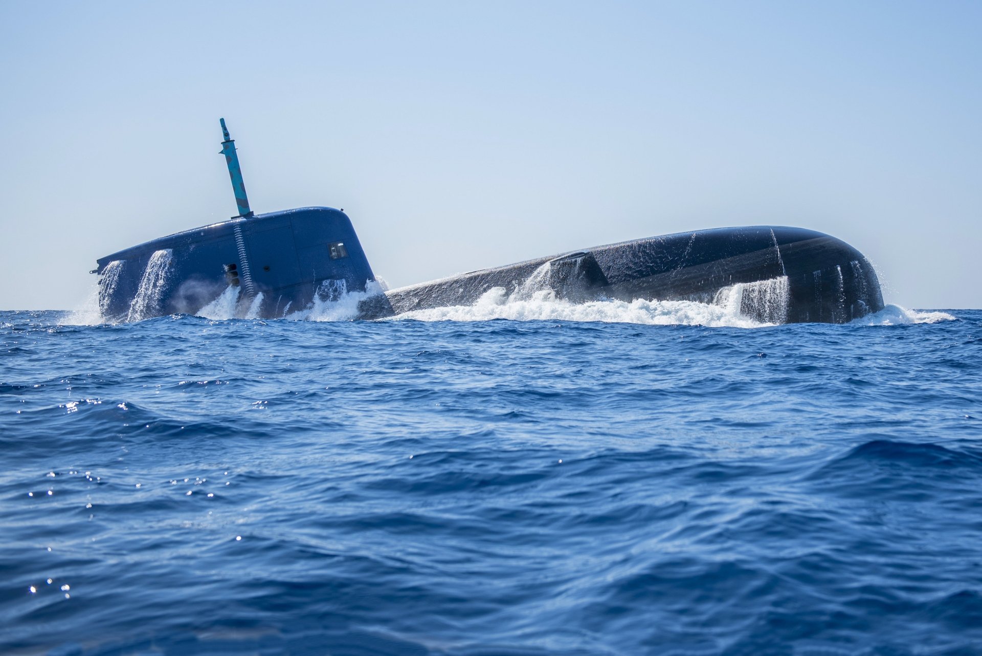 4K Ultra HD desktop wallpaper featuring a military submarine partially surfaced in the ocean with clear skies and calm blue waters.