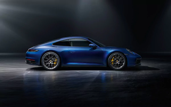 Side profile of a blue Porsche 911 Carrera sports car (Porsche 911) in a dark studio — Porsche vehicle and car rendered as a 4K Ultra HD PC desktop wallpaper background.