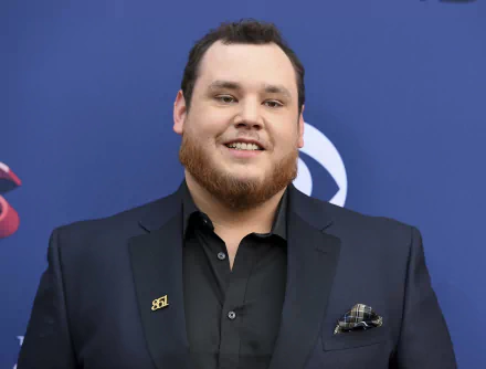 HD desktop wallpaper of a smiling man in a black suit at an event, providing a professional background ambiance.