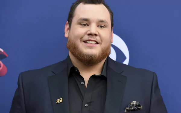 HD desktop wallpaper of a smiling man in a black suit at an event, providing a professional background ambiance.