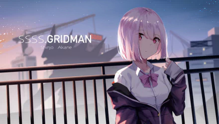 HD desktop wallpaper featuring Akane Shinjou from the anime SSSS.Gridman. She has short pink hair and pink eyes, set against a cityscape with evening sky and a large shadowy figure in the background.