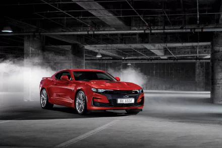 Red Chevrolet Camaro SS muscle car in a concrete parking garage, captured in sharp detail as a 4K Ultra HD PC desktop wallpaper/background.