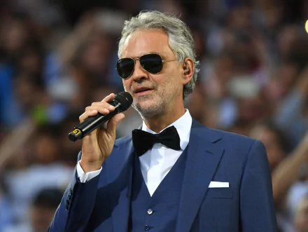 HD wallpaper featuring Andrea Bocelli in a suit with sunglasses, holding a microphone.