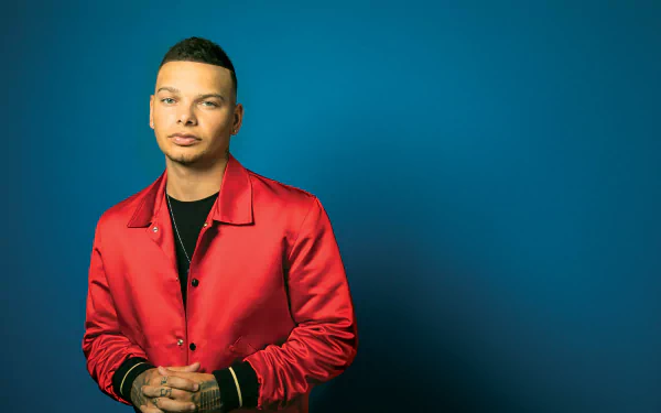 HD desktop wallpaper featuring a man in a red jacket against a blue background, tagged with Kane Brown.