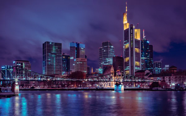 5K Ultra HD PC desktop wallpaper and background: Frankfurt, Germany skyline at night with illuminated skyscrapers and a lit bridge spanning the river in a dramatic man-made cityscape.