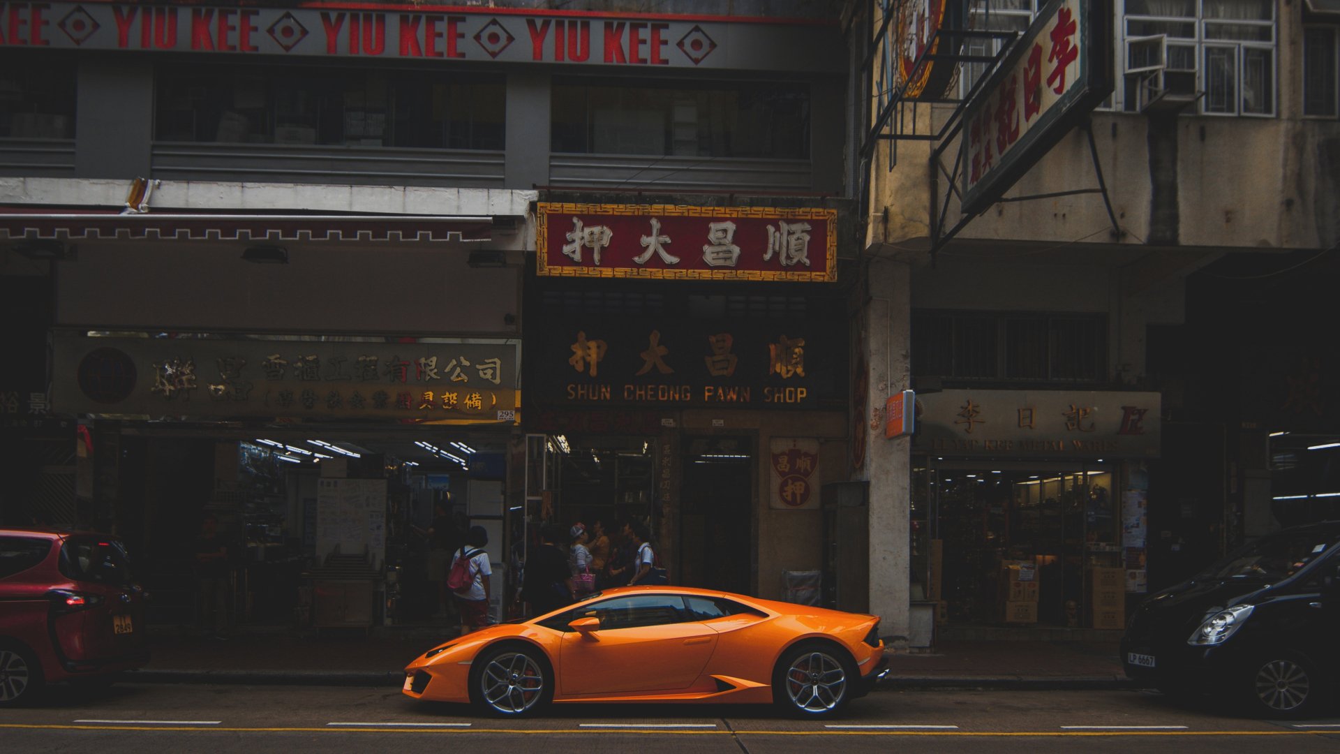 Orange Lamborghini Aventador vehicle parked on a Hong Kong street under neon signs — 5K Ultra HD PC desktop wallpaper and background.
