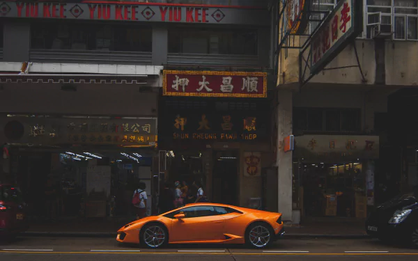 Orange Lamborghini Aventador vehicle parked on a Hong Kong street under neon signs — 5K Ultra HD PC desktop wallpaper and background.