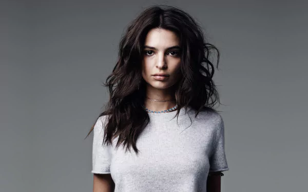 HD desktop wallpaper featuring American model and celebrity Emily Ratajkowski with brunette hair and brown eyes, set against a simple gray background.