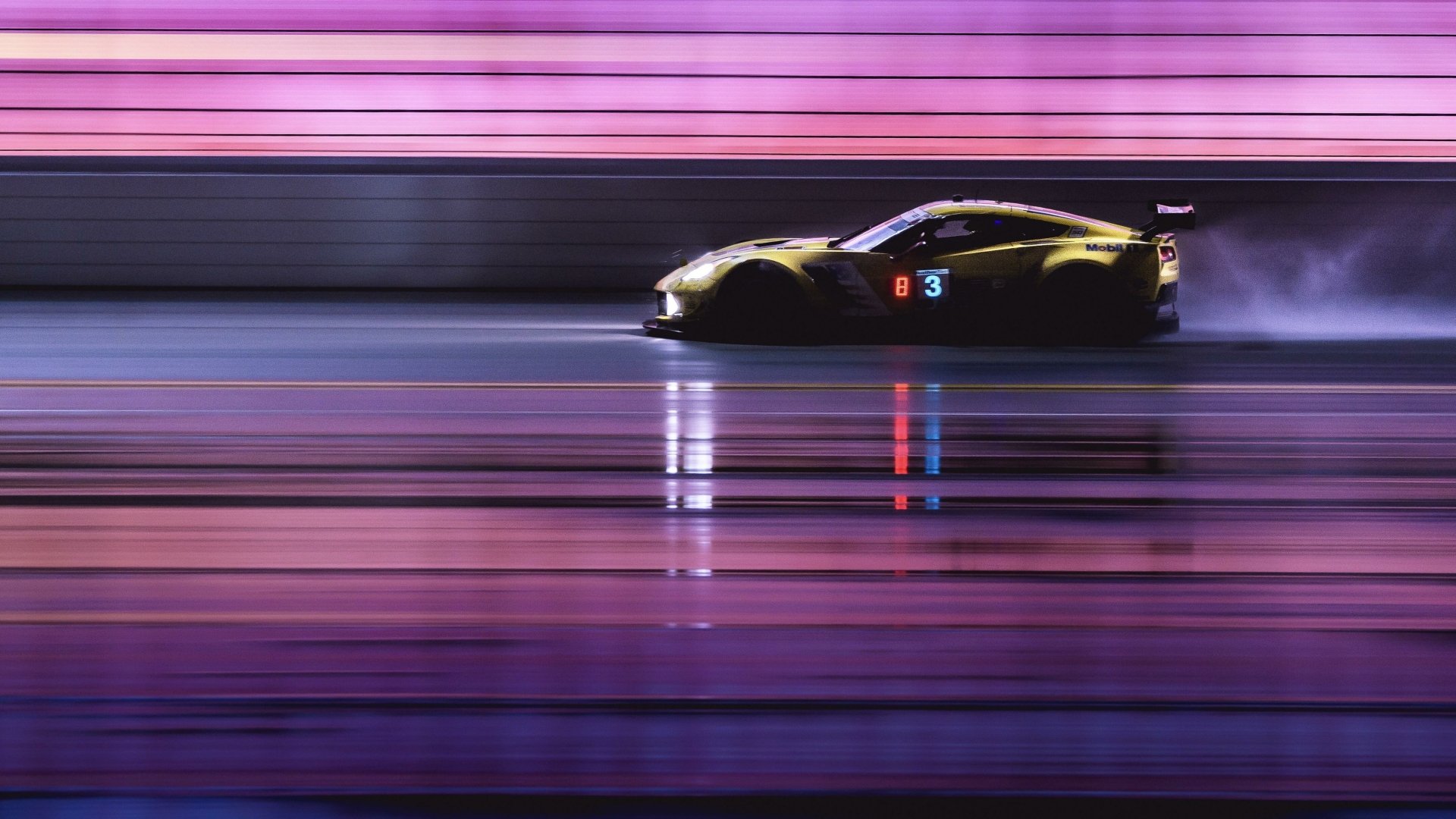 Side view of a Chevrolet Corvette racing at high speed, shown in motion blur with vibrant pink and purple lighting, featured as a 4K Ultra HD PC desktop wallpaper.