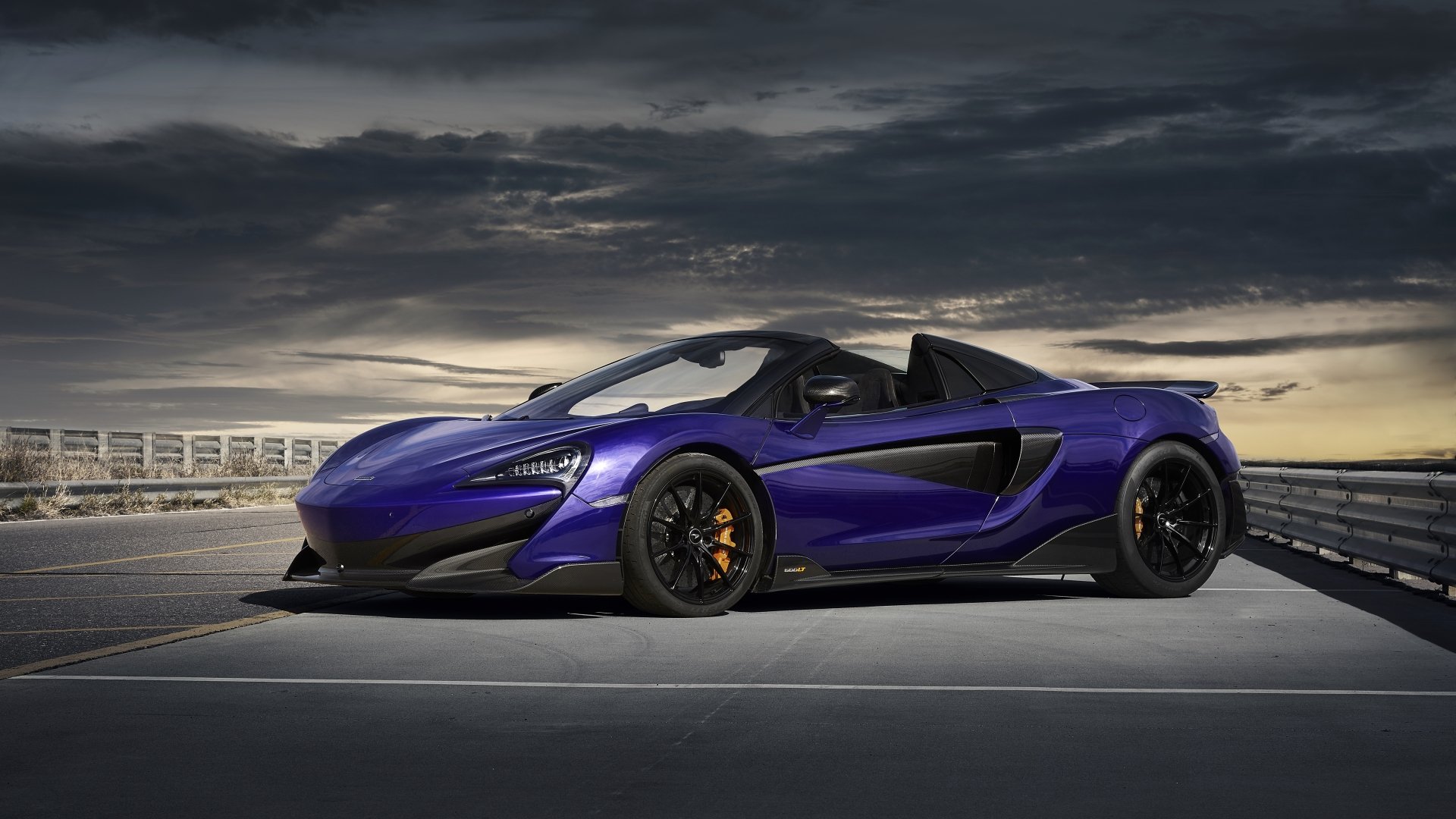 5K Ultra HD PC desktop wallpaper: purple McLaren 600LT supercar parked on a rooftop under a dramatic sky — sleek McLaren sports car vehicle background.