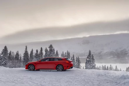 Red Kia Sportspace concept car parked on a snowy landscape with pine trees and misty mountains in the background, captured in 4K Ultra HD.
