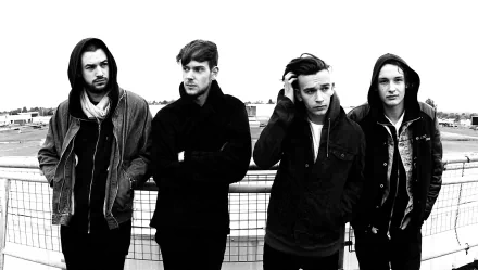 HD desktop wallpaper featuring the band The 1975 in a monochrome outdoor setting.