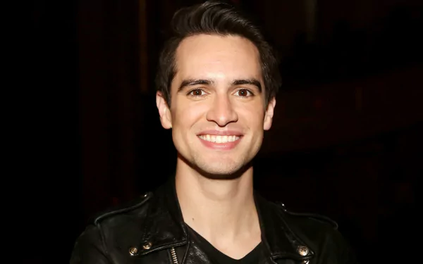 HD desktop wallpaper featuring a smiling member of Panic! at the Disco in a black leather jacket.
