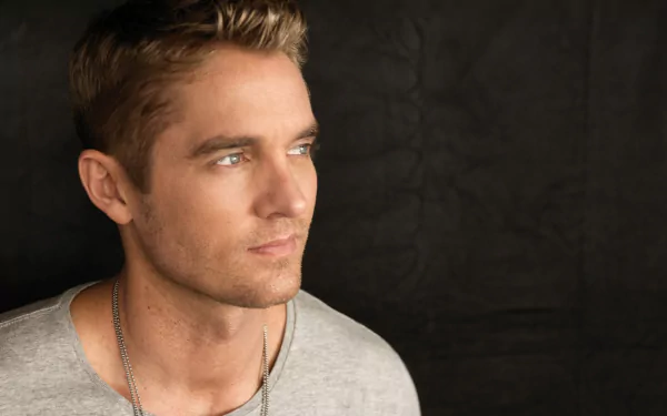 HD desktop wallpaper and background featuring a thoughtful man with blue eyes and a grey tee, against a dark backdrop.
