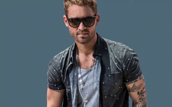 HD desktop wallpaper featuring a man in sunglasses and a denim jacket against a muted teal background.